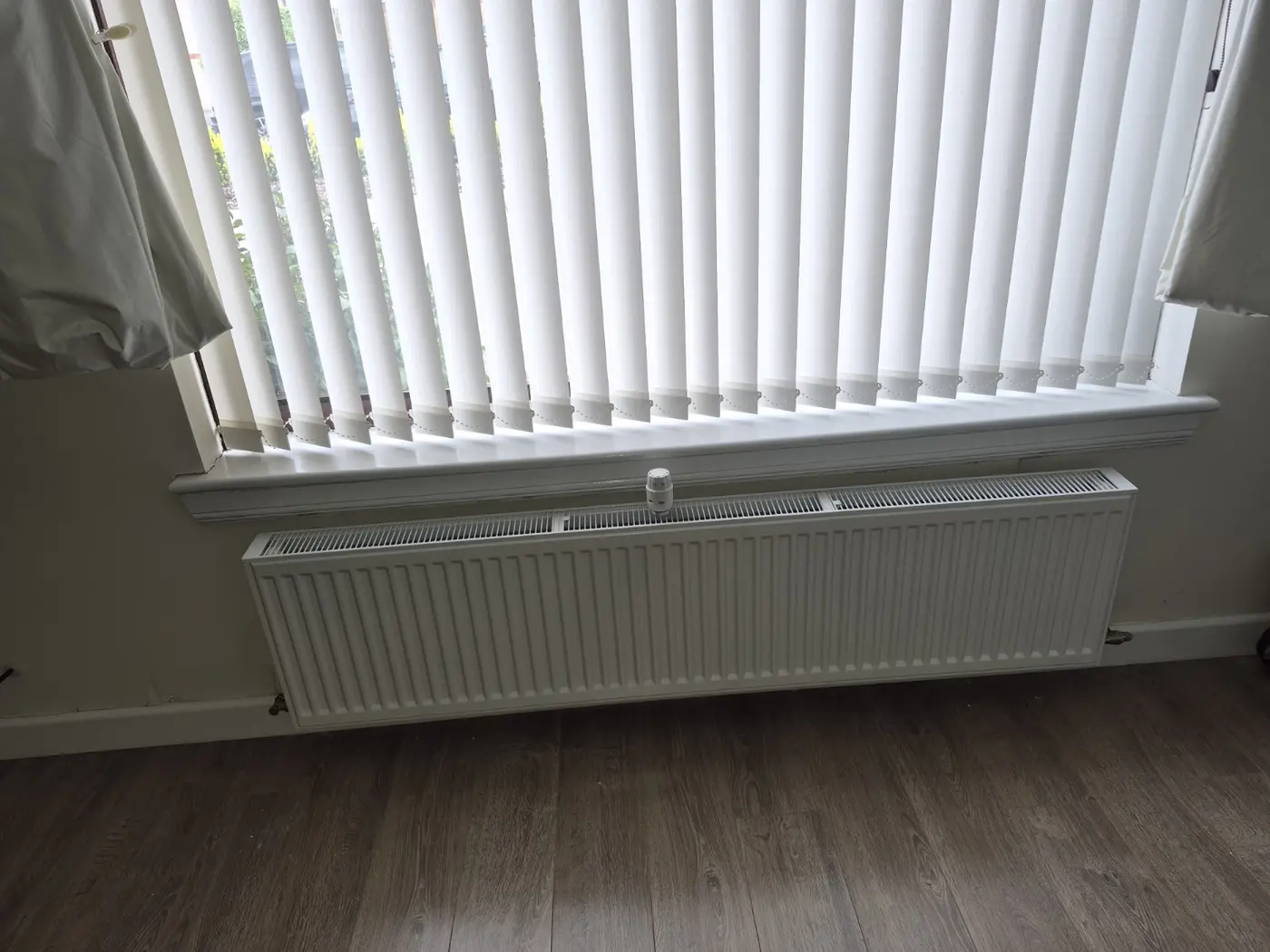 Finished radiator installation beneath a window